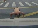 洛隆路一男子赤裸上身过马路，突然在路中央对着小车跪拜磕头